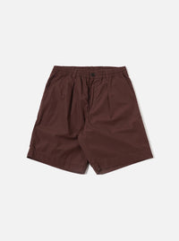 The Brown Peached Poplin Pleated Track Short is shown as a flat lay against a plain white background. The shorts feature an elasticated waistband, a single pleat on each leg, and two large patch pockets on the front. The brown cotton poplin fabric has a smooth, matte finish.