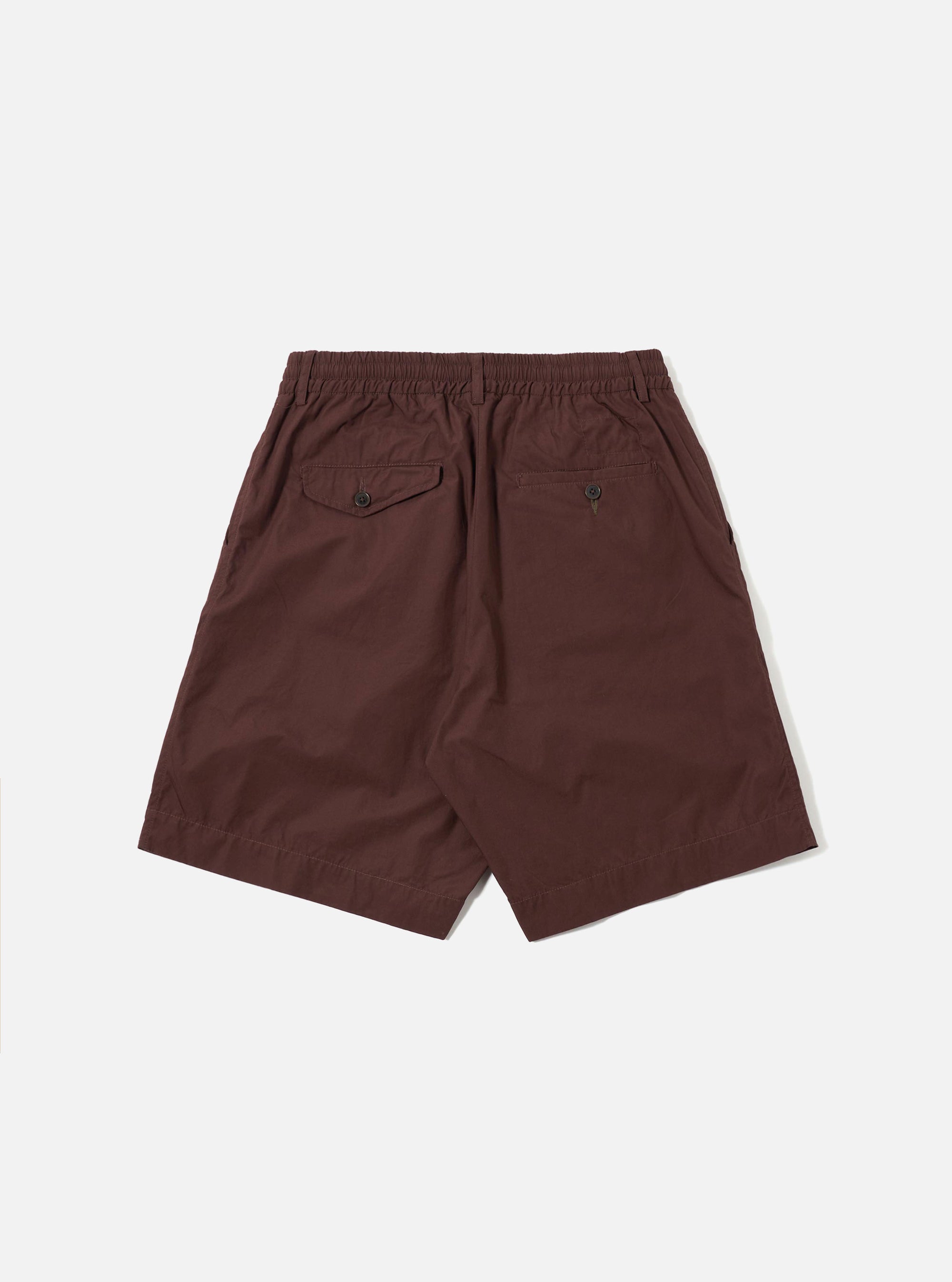 The Brown Peached Poplin Pleated Track Short is shown from the back as a flat lay against a plain white background. The image highlights the elasticated waistband, a single rear patch pocket on the right side, and the smooth texture of the brown cotton poplin fabric.