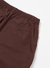 The Brown Peached Poplin Pleated Track Short is shown from the back as a flat lay against a plain white background. The image highlights the elasticated waistband and a single rear patch pocket. The brown cotton poplin fabric has a smooth, matte finish.