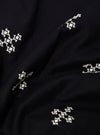 A close-up fabric swatch of the Black Embroidered Diamond Camp Shirt highlights the intricate diamond-patterned embroidery stitched in a slightly lighter thread against the black viscose fabric. The texture of the material and the detailed geometric pattern are the focal points of the image. No model or mannequin is present.