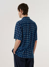 A model wears the Indigo Block Print Circles Camper Shirt against a plain white background. The shirt features an all-over pattern of white circular block prints on a deep indigo base. Shown from the back, the image highlights the shirt's relaxed fit, straight hem, and short sleeves. No mannequin is present in the image.