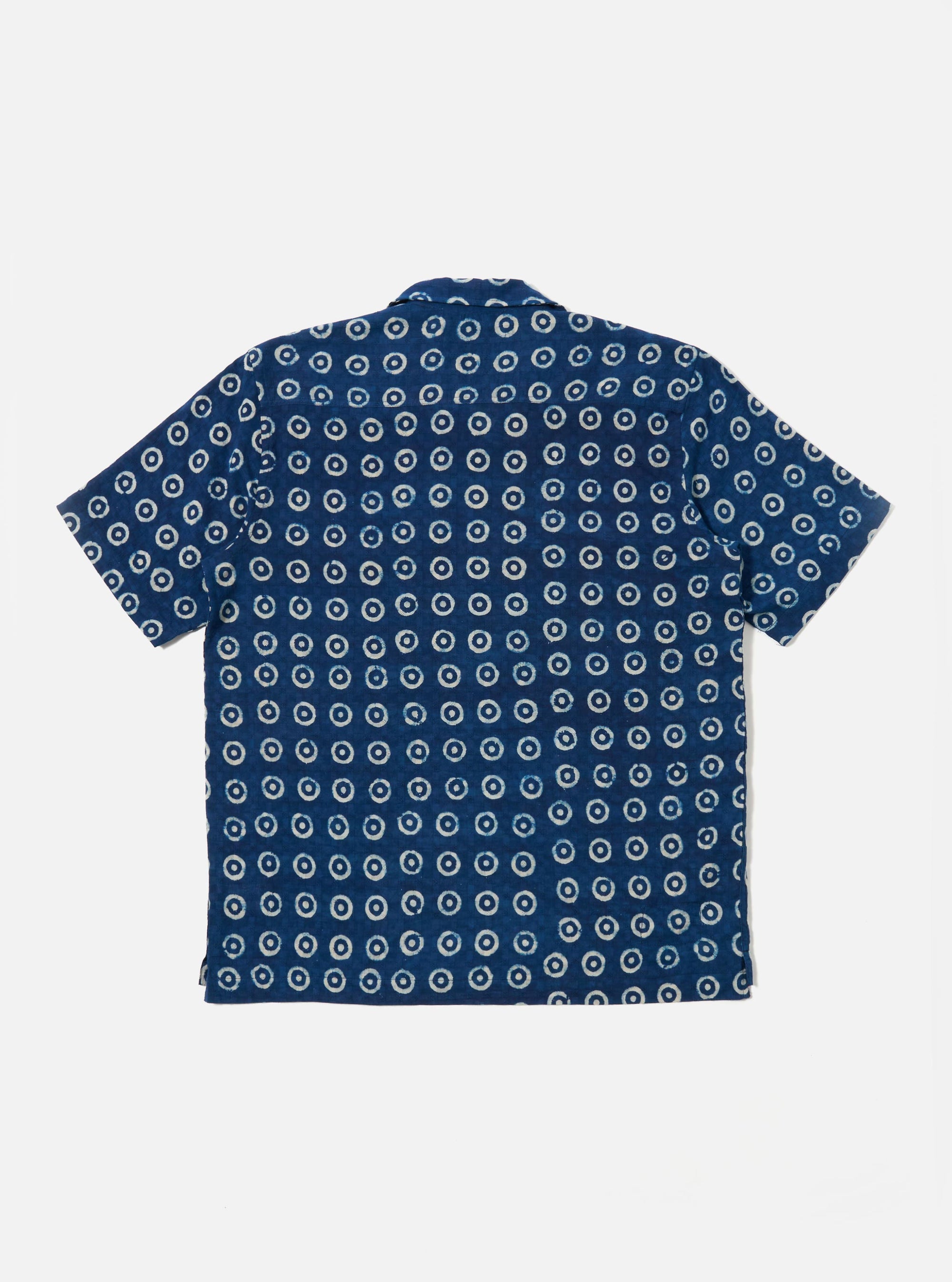 The Indigo Block Print Circles Camper Shirt is shown from the back as a flat lay against a plain white background. The shirt features an all-over pattern of white circular block prints on a dark indigo base, a horizontal back yoke, and a straight hem.