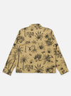 The Sand Jungle Toile Twill Windcheater Jacket is shown from the back as a flat lay against a plain white background. The jacket features an all-over intricate jungle toile print with dark botanical and animal illustrations on a sand-colored base. The garment is constructed with a simple back panel, a straight hem, and a standard collar.
