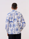 A model wears the White Jungle Toile Poplin Fatigue Shirt, shown from the back against a plain white background. The shirt features an all-over dark jungle print with botanical and animal motifs on a white base. The image highlights the relaxed fit, straight hem, and the smooth texture of the cotton poplin fabric.