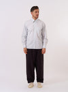 The Sky Urban Stripe Lazy Day Shirt is shown as a flat lay against a white background. The shirt features a light blue and white vertical stripe pattern, a button-down collar, and a single asymmetrical chest pocket on the left side. It has a relaxed fit with a straight hem.