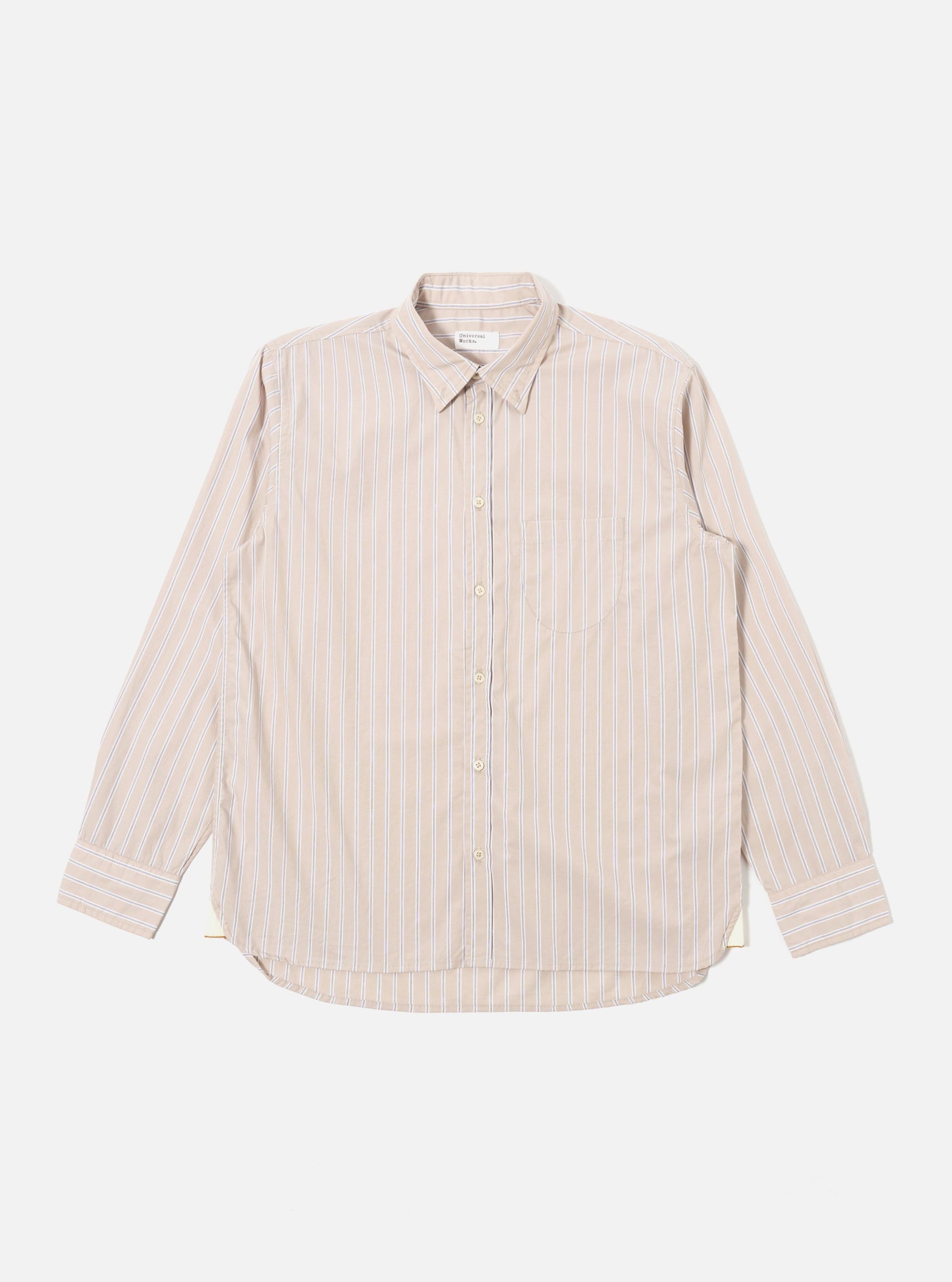 The Sand Urban Stripe Lazy Day Shirt is presented as a flat lay against a plain white background. The long-sleeved shirt features a vertical striped pattern in sand and white, a button-down collar, and a visible asymmetrical chest pocket on the left side. The hem is slightly curved, and the full button placket is centered.