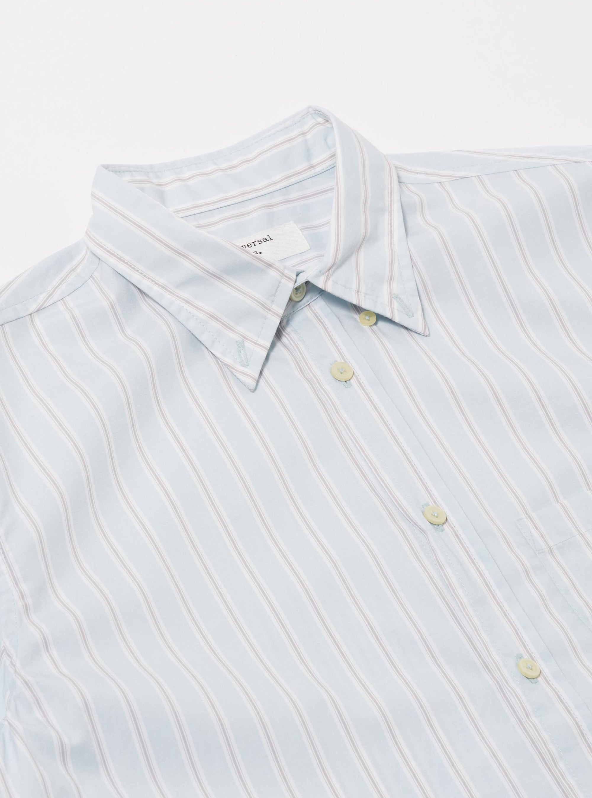 The Sky Urban Stripe Lazy Day Shirt is shown from a rear angle as a flat lay against a plain white background. The image highlights the back yoke with a box pleat and the light blue and white vertical stripe pattern of the cotton fabric.