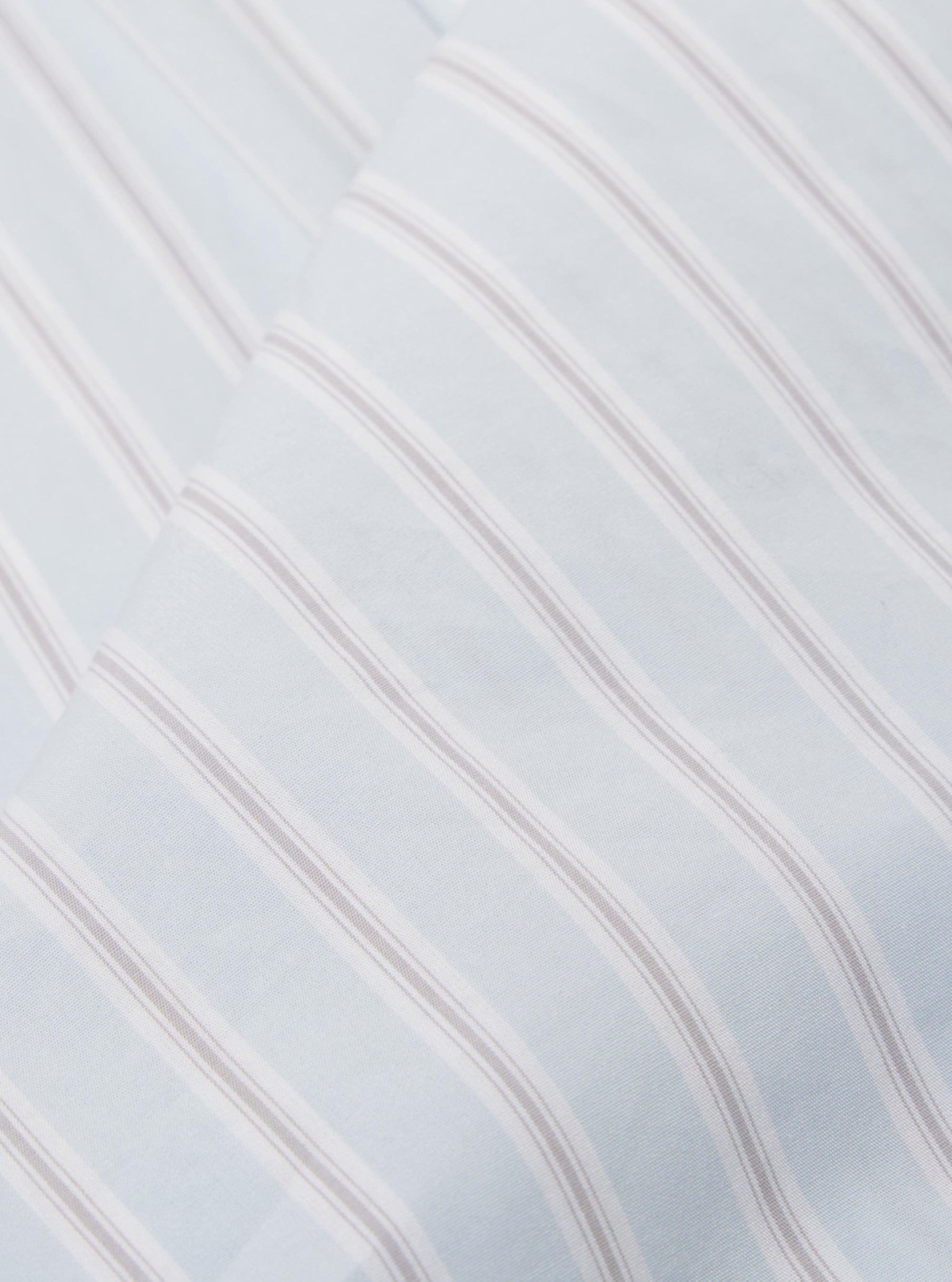 A close-up fabric swatch of the Sky Urban Stripe Lazy Day Shirt highlights the light blue and white vertical stripe pattern. The cotton fabric shows a fine weave and a smooth texture.