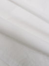 A close-up swatch of the White Poplin Dwight Overshirt highlights the smooth and tightly woven texture of the white cotton poplin fabric. The material fills the frame, providing a detailed view of the garment's clean, crisp finish and solid white color.