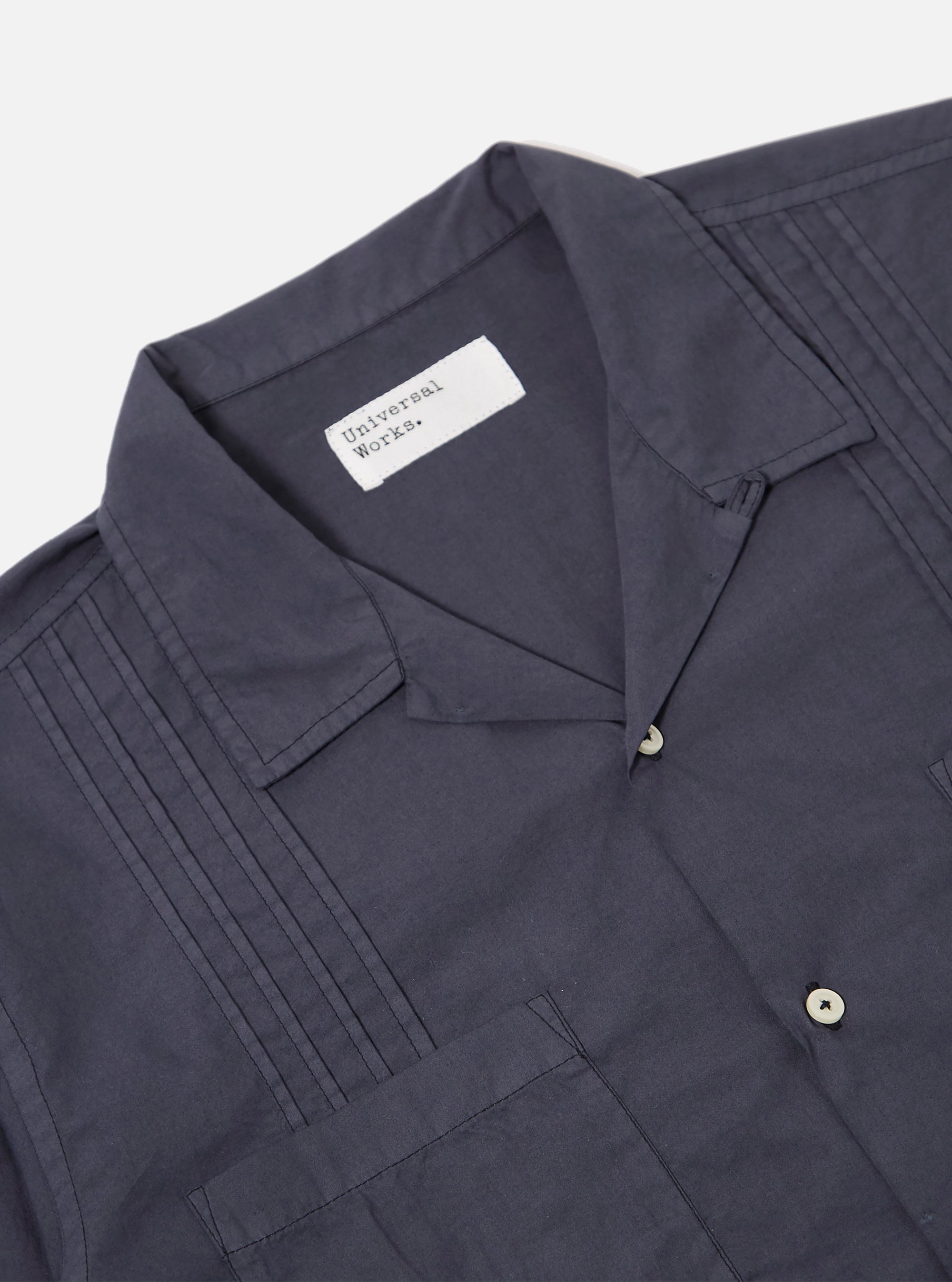 The Navy Poplin Dwight Overshirt is shown from the back as a flat lay against a plain white background. The image highlights the straight hem, the back yoke, and the long sleeves with buttoned cuffs.