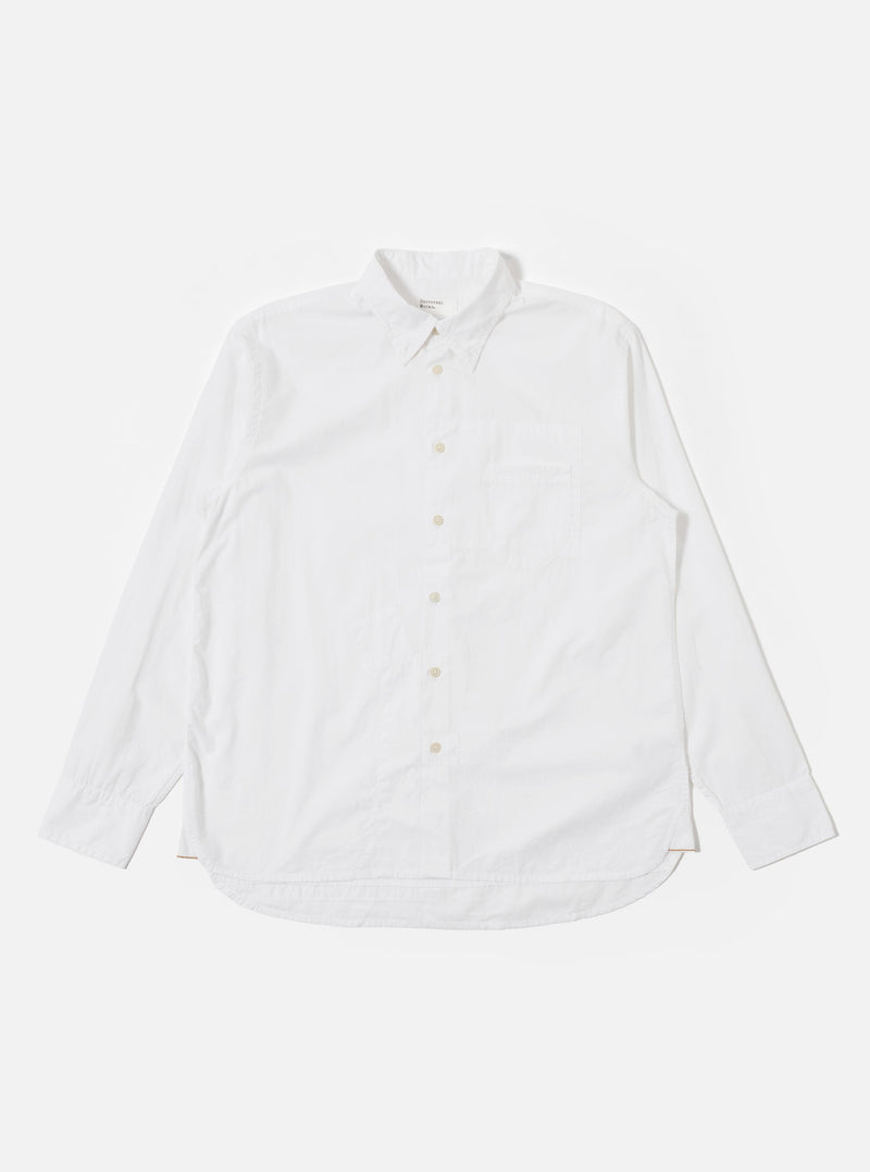 The White Poplin Patched Lazy Day Shirt is shown as a flat lay against a plain white background. The shirt features a relaxed fit, a simple pointed collar, and a central button-down front. A prominent design element is the single asymmetric chest pocket. The fabric is a crisp, solid white cotton poplin.