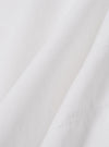 A close-up fabric swatch of the White Poplin Patched Lazy Day Shirt highlights the smooth, fine weave of the ecru cotton poplin material. The image focuses on the textile detail and color. No model or mannequin is present.