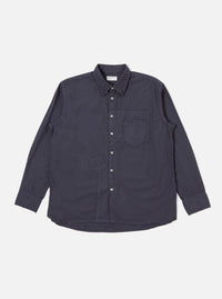 The Navy Poplin Patched Lazy Day Shirt is shown as a flat lay against a white background. The shirt is a deep navy blue and features a classic button-down collar, a full-button front, and long sleeves with buttoned cuffs. A prominent feature is the single asymmetrical patch pocket on the chest. The fabric has a smooth poplin texture.