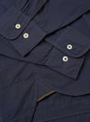 The Navy Poplin Patched Lazy Day Shirt is shown in a detail view as a flat lay against a plain white background. The image highlights the smooth texture of the navy blue cotton poplin fabric and the construction of the pointed collar and top button.