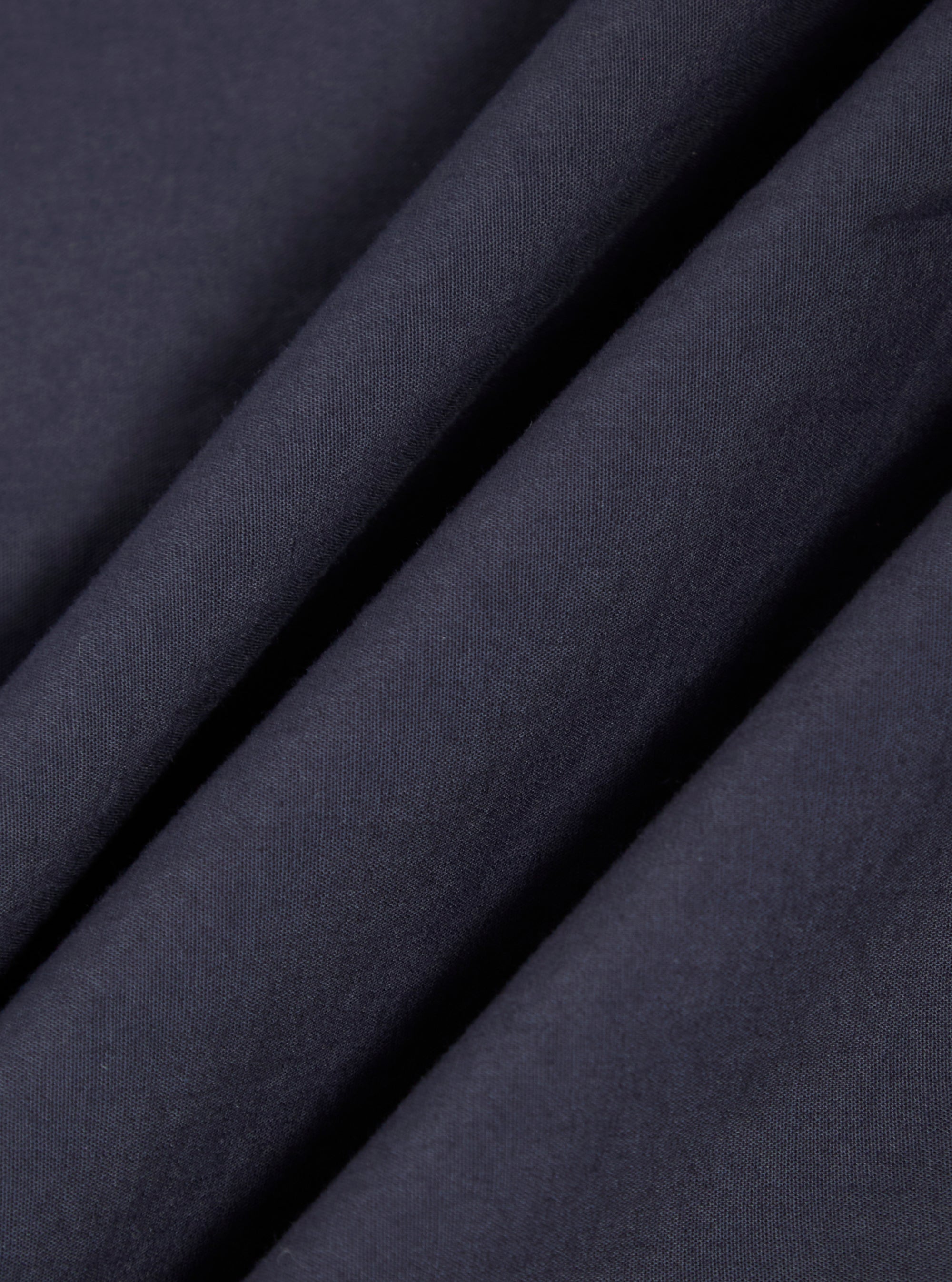 A close-up fabric swatch of the Navy Poplin Patched Lazy Day Shirt displays a deep navy blue color and a smooth, tightly woven cotton poplin texture.