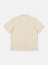 The Ecru Dot Waffle Road Shirt is shown from the back as a flat lay against a plain white background. The image highlights the shirt's straight hem, short sleeves, and the unique textured dot waffle cotton fabric in an ecru shade.