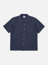 The Navy Dot Waffle Road Shirt is shown as a flat lay against a plain white background. The shirt features short sleeves, a camp collar with a loop closure at the neck, and a single chest patch pocket on the left side. The fabric has a distinct textured waffle pattern throughout.