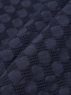 A close-up fabric swatch of the Navy Dot Waffle Road Shirt is shown, highlighting the deep navy blue color and the intricate waffle-weave texture with a subtle dot pattern. The textured cotton fabric fills the frame.