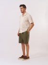 The Ecru 3D Flower Road Shirt is shown as a flat lay against a white background. The shirt features a short-sleeve design with a one-piece loop-close collar, a straight hem, and a single chest patch pocket on the left side. The fabric is decorated with tonal 3D flower appliqués throughout the body.
