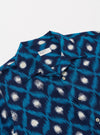 The Indigo Diamond Ikat Deck Shirt is shown from the back as a flat lay against a plain white background. The shirt features a dark indigo base with a repeating white diamond ikat pattern throughout. It has short sleeves and a straight hem.
