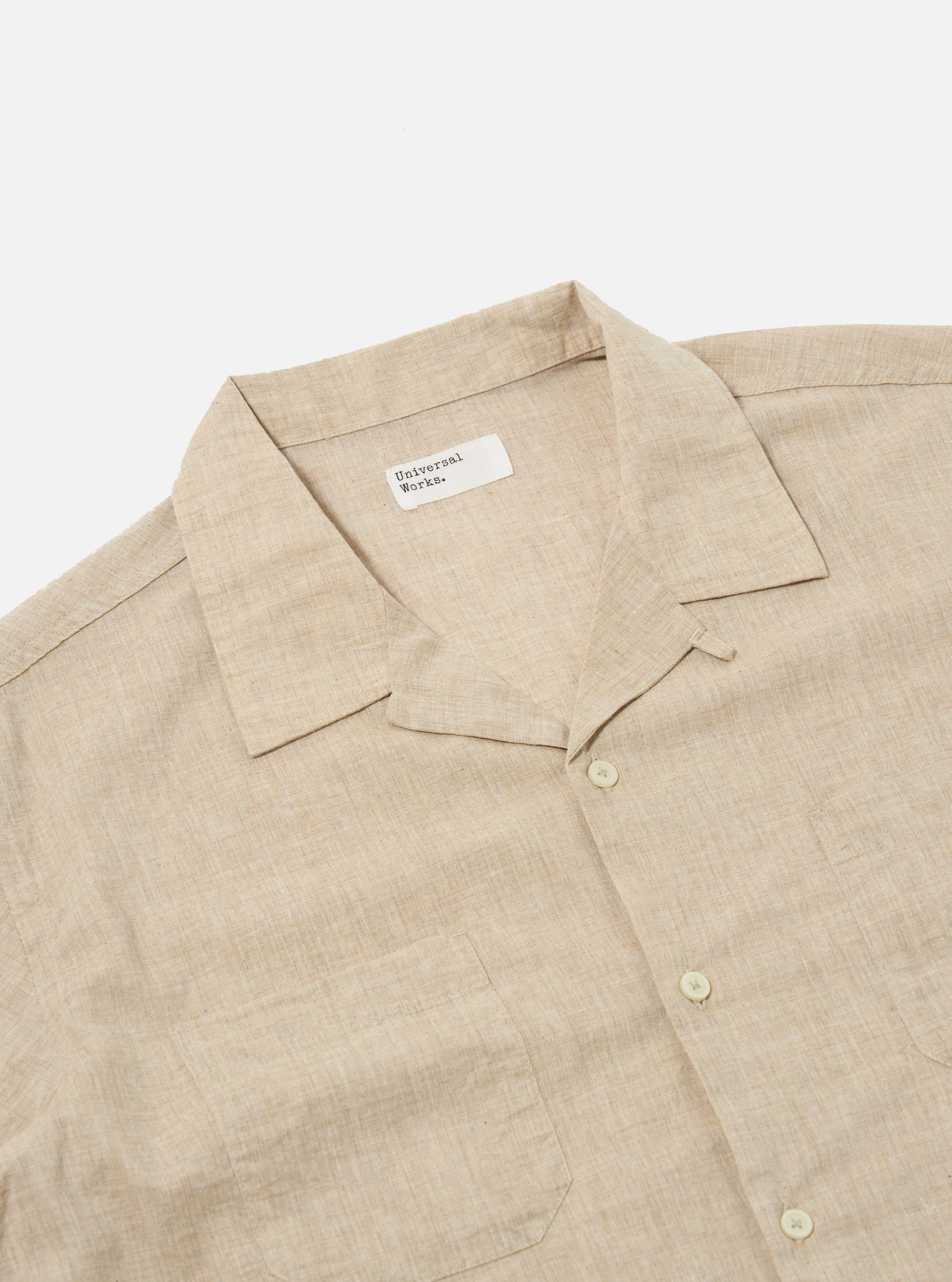 The Beige Fine Organic Cotton Sal Road Shirt is shown from the back as a flat lay against a plain white background. The image highlights the shirt's straight hem, short sleeves, and the soft marled texture of the beige organic cotton fabric. The single-piece collar and clean construction of the rear panel are clearly visible.
