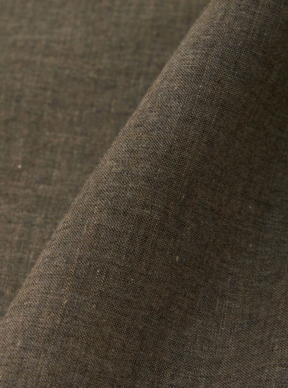 A close-up fabric swatch of the Brown Fine Organic Cotton Sal Road Shirt highlights the lightweight, loose weave of the 100% organic cotton. The image focuses on the rich brown color and the fine texture of the material.