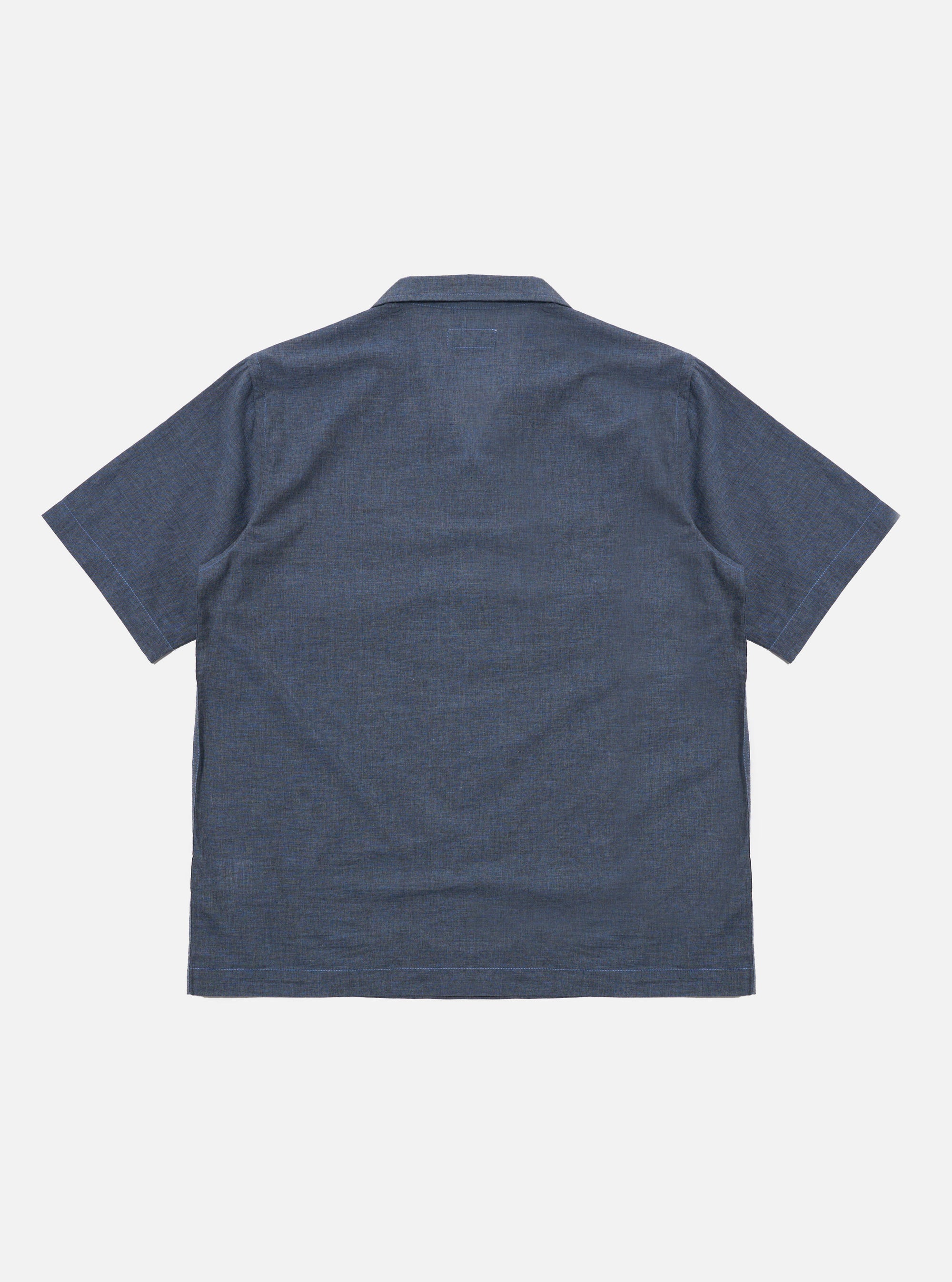 The Indigo Fine Organic Cotton Sal Road Shirt is shown from the back as a flat lay against a plain white background. The image highlights the clean construction of the shirt's rear panel, the simple straight hem, and the deep blue indigo color of the fine organic cotton fabric.