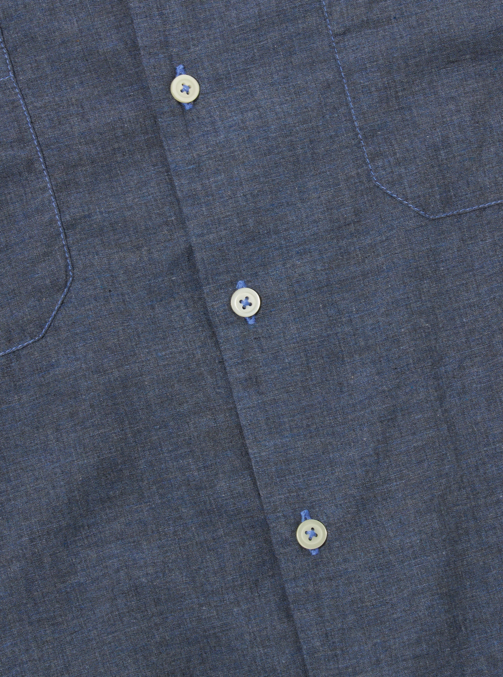 The Indigo Fine Organic Cotton Sal Road Shirt is shown from the back as a flat lay against a plain white background. The image highlights the shirt's straight hem, short sleeves, and the deep indigo color of the fine organic cotton fabric.