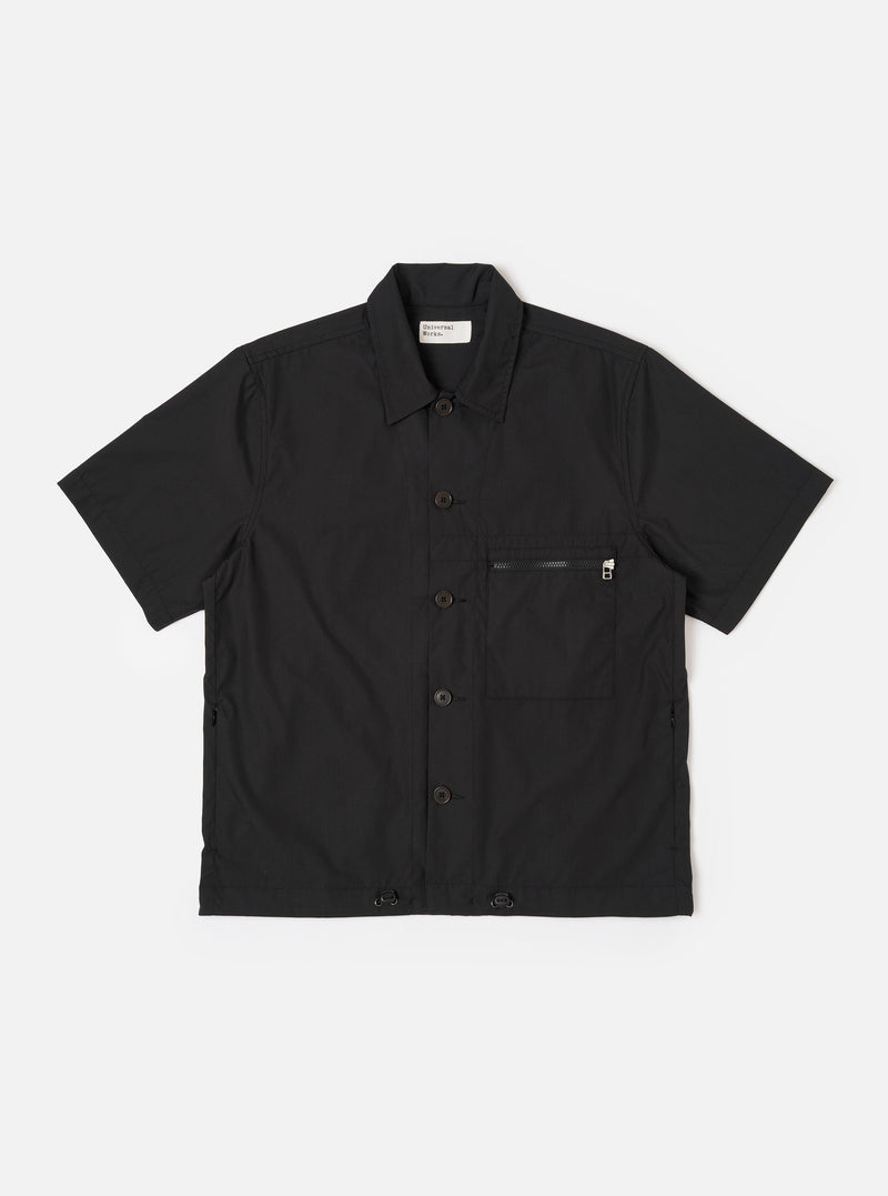 The Black Recycled Polytech Z Tech Overshirt is shown as a flat lay against a white background. The overshirt features a one-piece collar, a central button-down closure, and a visible zip-closure patch pocket on the left chest. The black recycled polytech fabric has a smooth finish.