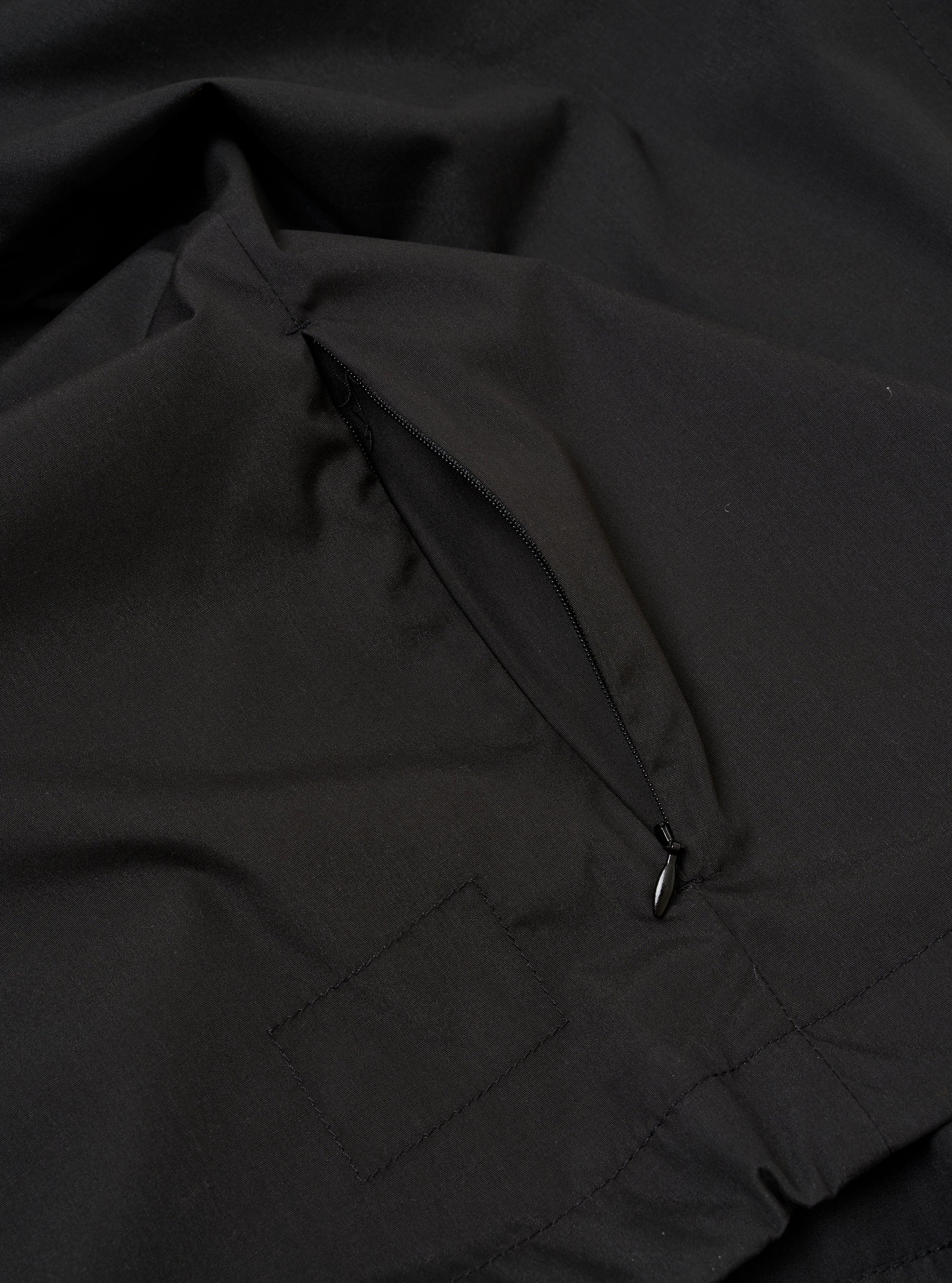 The Black Recycled Polytech Z Tech Overshirt is shown from the back as a flat lay against a plain white background. The image highlights the garment's clean, black recycled polytech fabric, a straight hem, and a back yoke with a central box pleat.