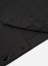 The Black Recycled Polytech Z Tech Overshirt is shown in a detail view as a flat lay against a plain white background. The image highlights the smooth, technical texture of the black recycled polytech fabric and the construction of the reinforced chest pocket with a horizontal zip closure.