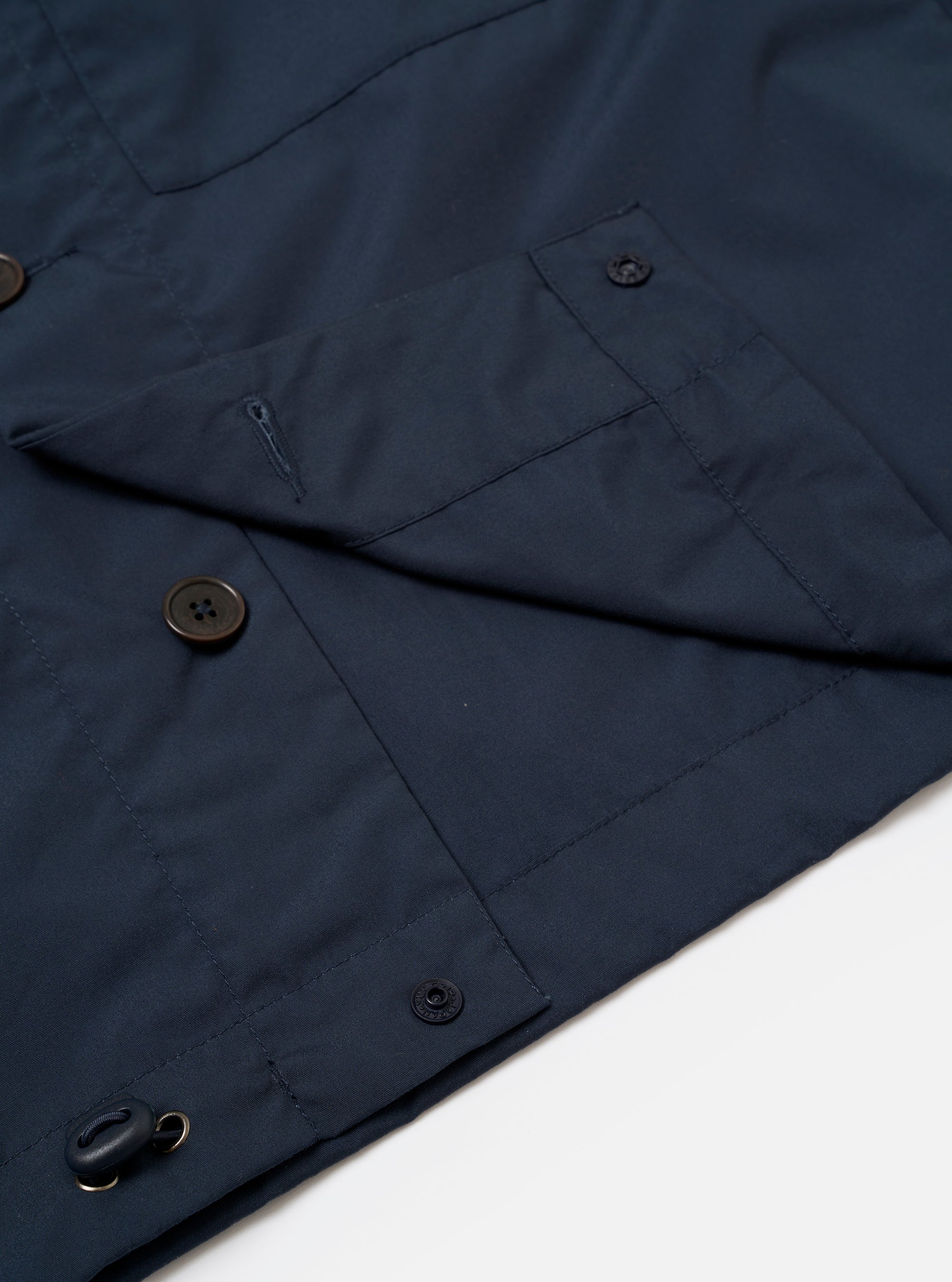 The Navy Recycled Polytech Z Tech Overshirt is shown in a detail view as a flat lay against a plain white background. The image focuses on the smooth texture of the dark navy recycled polytech fabric and the construction of the technical zip-up chest pocket.