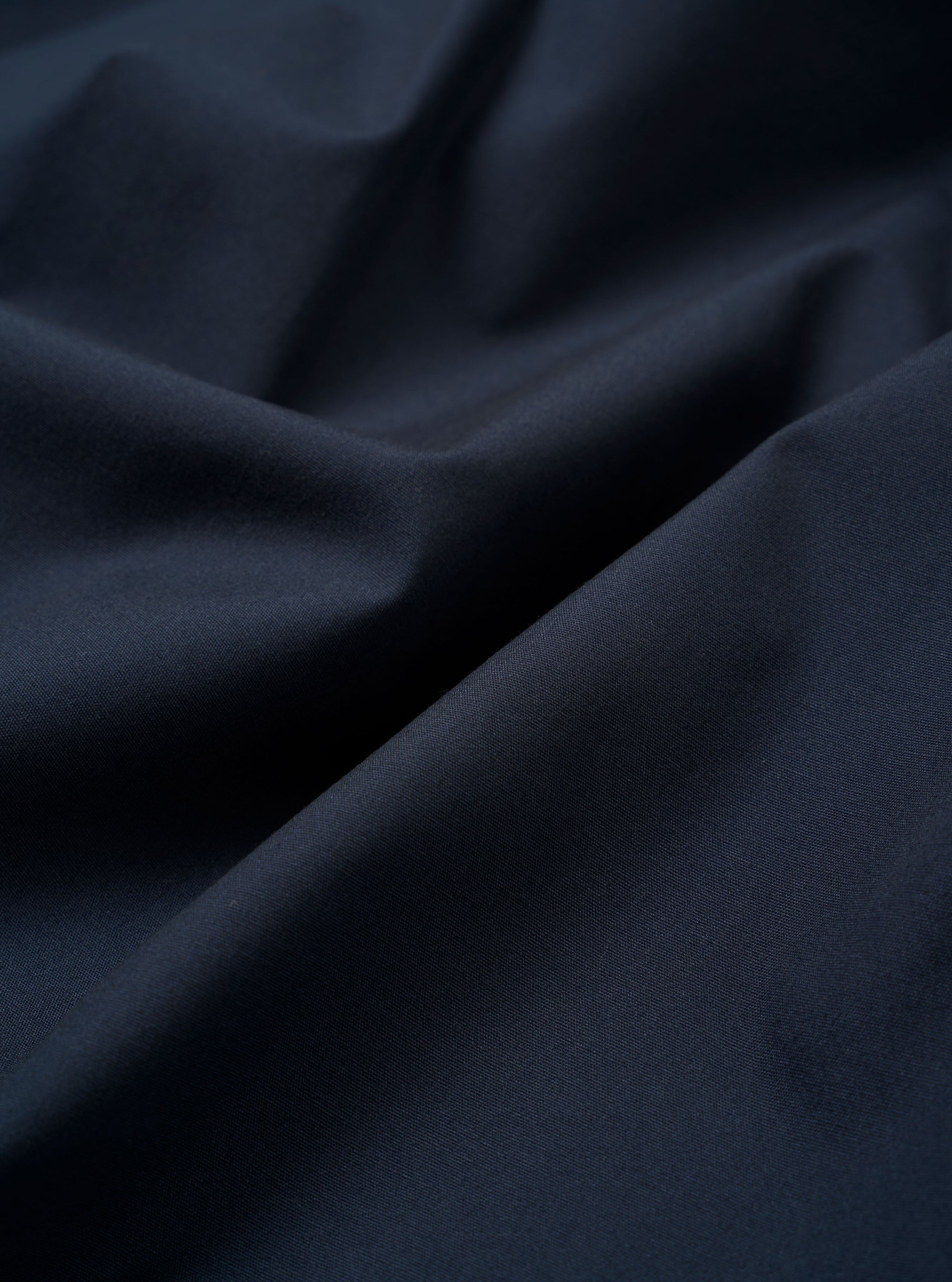 The Navy Recycled Polytech Z Tech Overshirt is shown in a detail view as a flat lay against a plain white background. The image focuses on the technical texture of the dark navy recycled fabric, highlighting the zip-front closure and the clean stitching of a chest patch pocket.