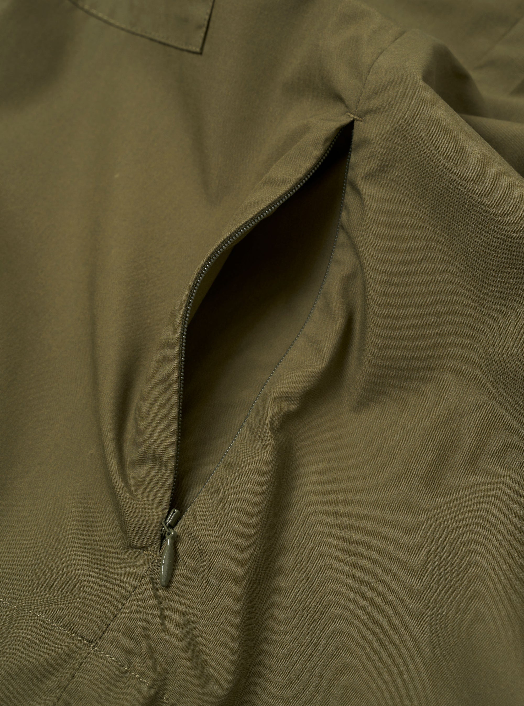 The Olive Recycled Polytech Z Tech Overshirt is shown from the back as a flat lay against a plain white background. The image highlights the clean construction of the garment's rear panel, the smooth olive green recycled polytech fabric, and a straight hem.