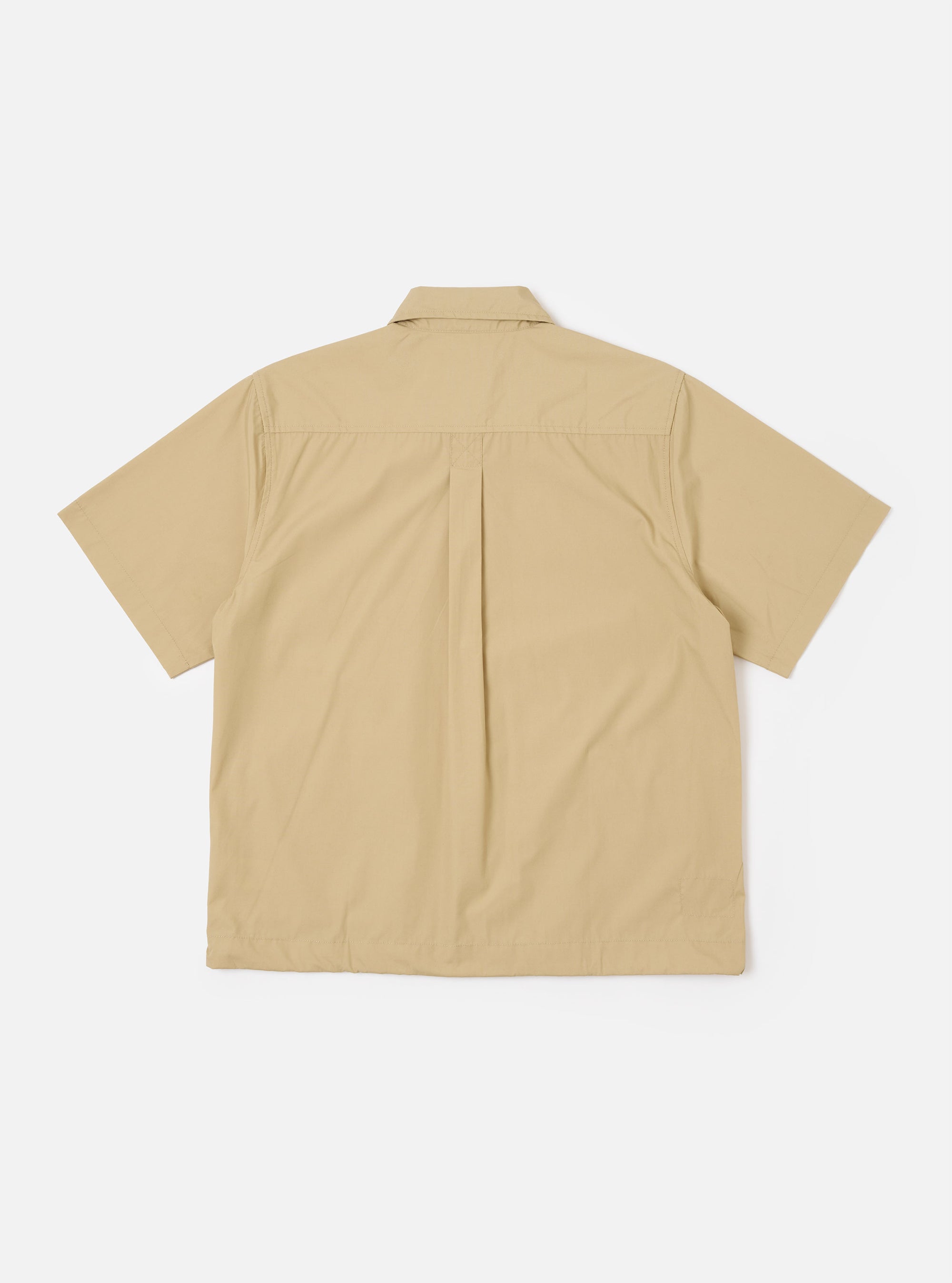 The Sand Recycled Polytech Z Tech Overshirt is shown from the back as a flat lay against a plain white background. The image highlights the garment's boxy fit, a back yoke with a central box pleat, and a clean, straight hem. The sand-colored fabric has a smooth, technical appearance.
