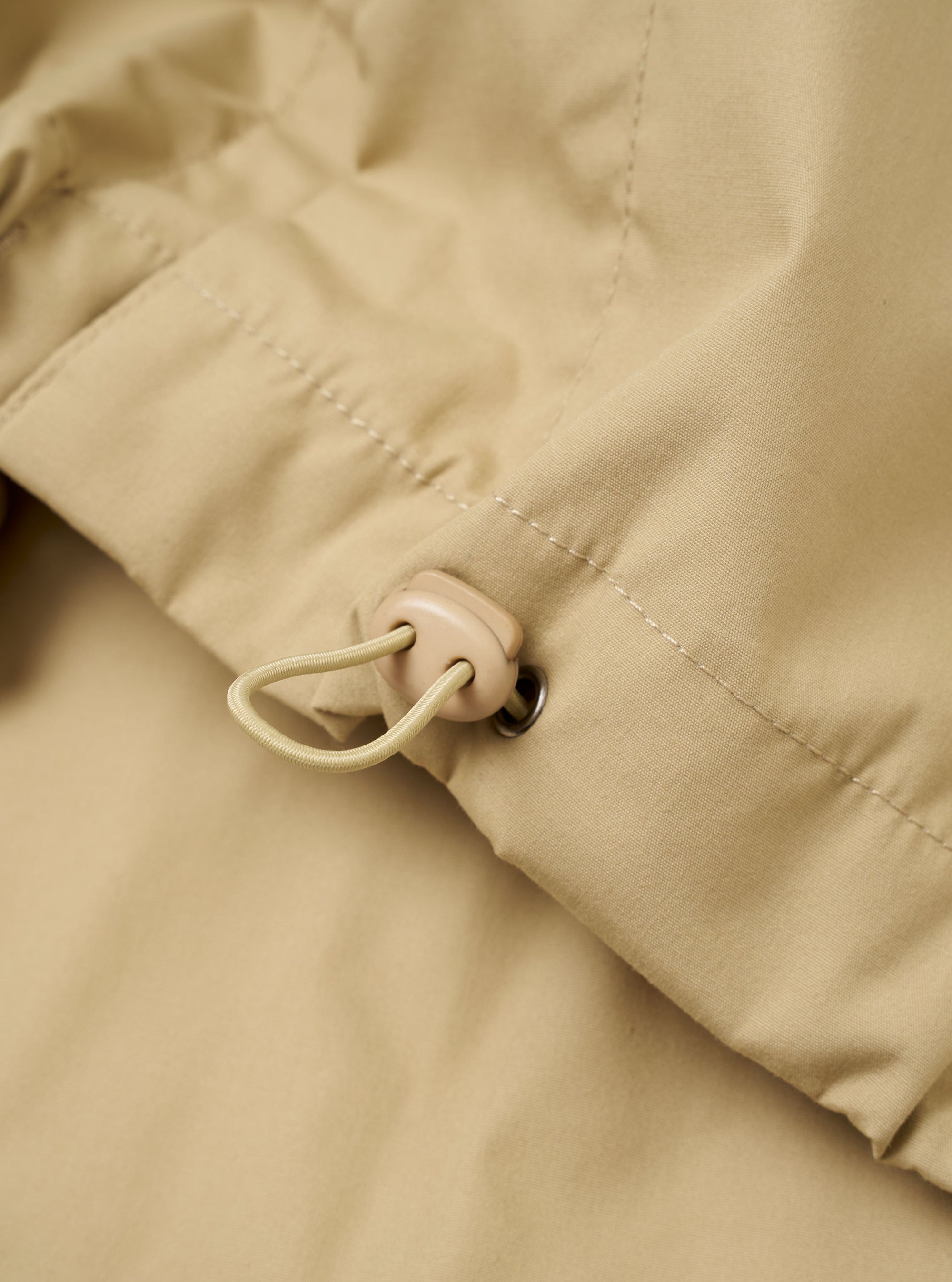 The Sand Recycled Polytech Z Tech Overshirt is shown from the back as a flat lay against a plain white background. The image highlights the smooth, structured recycled polytech fabric in a light sand color, featuring a straight back yoke and a simple, clean hemline.