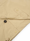 The Sand Recycled Polytech Z Tech Overshirt is shown as a flat lay against a plain white background. The image focuses on a detail of the garment, highlighting the smooth texture of the sand-colored recycled polytech fabric and a sleeve featuring an elasticated cuff and a drawstring adjustment.