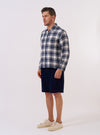 The Navy Texture Plaid Zip Shirt is presented as a flat lay against a plain white background. The shirt features a full-length central zip closure, a structured collar, and a single chest patch pocket. The fabric displays a distinct navy blue and white textured plaid pattern throughout.