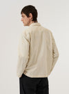 A model is wearing the Stone Seo Recycled Nylon Zip Too Shirt, shown from the back against a plain white background. The shirt features a relaxed fit, a straight hem, and a simple back panel with a horizontal yoke. The lightweight stone-colored recycled nylon fabric has a smooth, technical appearance. The model is standing with their back to the camera, highlighting the garment's clean lines and sleeveless silhouette.
