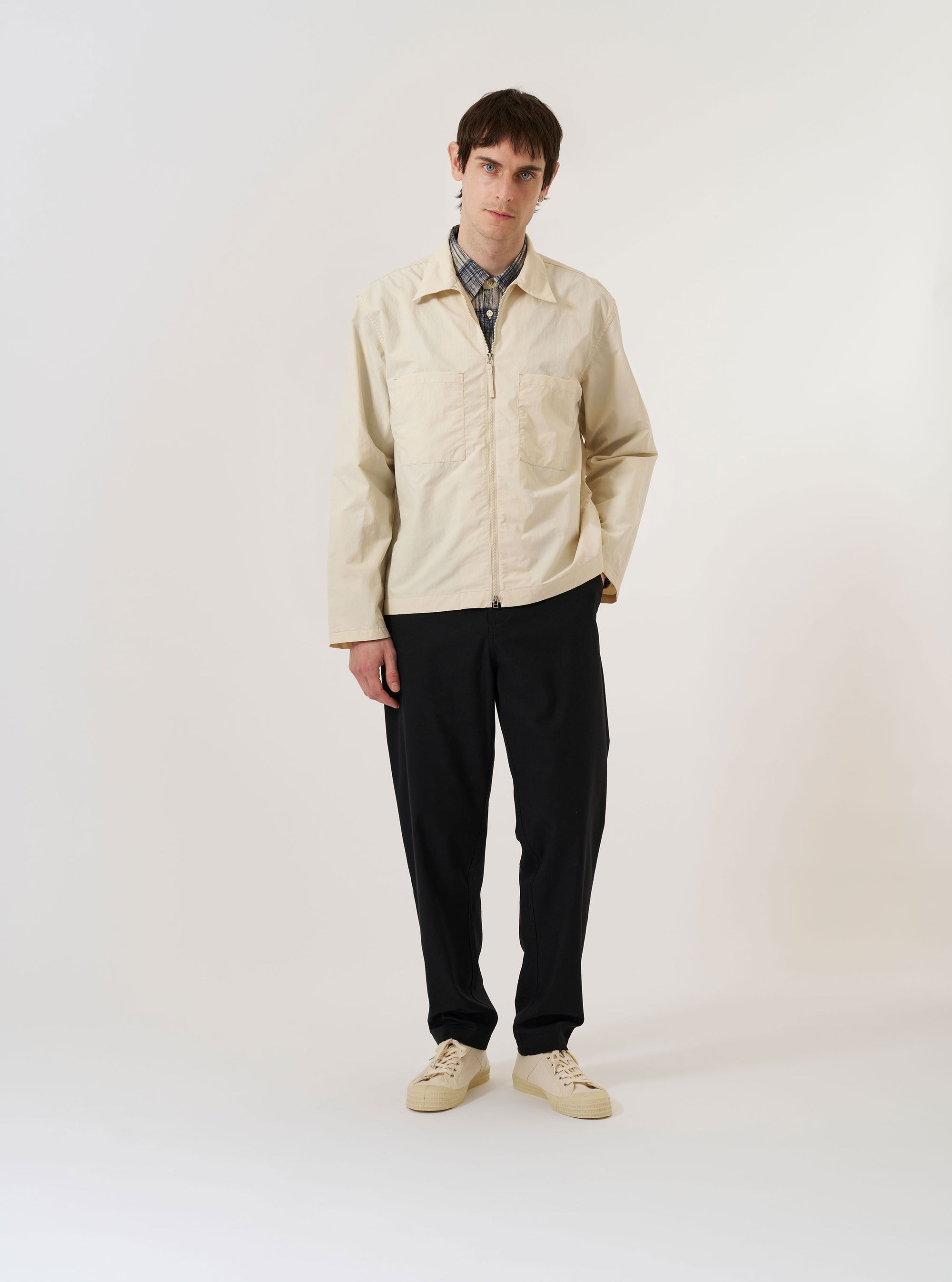 The Stone Seo Recycled Nylon Zip Too Shirt is shown as a flat lay against a plain white background. The shirt features a full-length central zip closure, a classic pointed collar, and two large patch pockets on the chest. The garment is made from a smooth, stone-colored recycled nylon fabric.