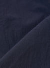 A close-up fabric swatch of the Navy Seo Recycled Nylon Zip Too Shirt highlights the smooth, technical texture of the recycled nylon material. The fabric is a solid, deep navy blue with a slight matte finish and a visible fine-grained weave.