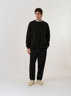 The Black Brush Back Sweat Billy Sweat is shown as a flat lay against a plain white background. The sweatshirt features a classic crew neckline, long sleeves with ribbed cuffs, and a ribbed hem. The black cotton fabric has a soft, matte finish.