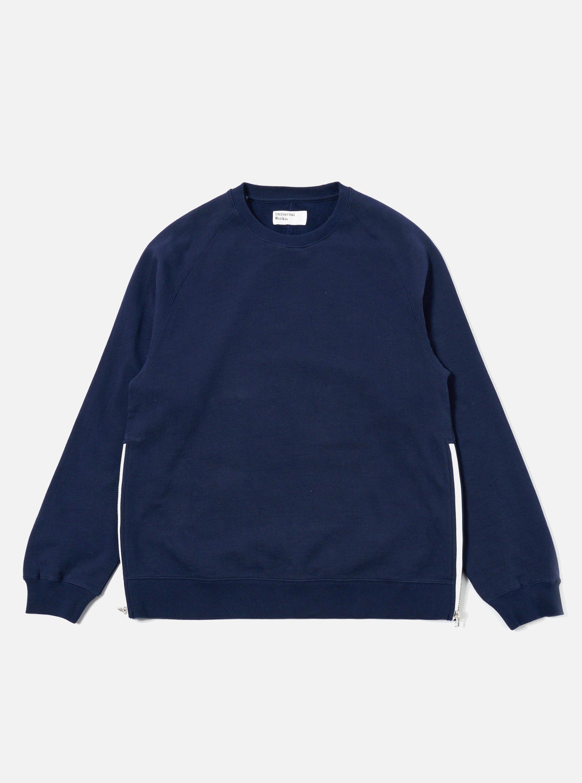 The Navy Brush Back Sweat Billy Sweat is shown as a flat lay against a plain white background. The sweatshirt features a classic crew neckline, ribbed cuffs, and a ribbed hem. The garment is made from a soft navy blue cotton fabric with a visible fine-knit texture.