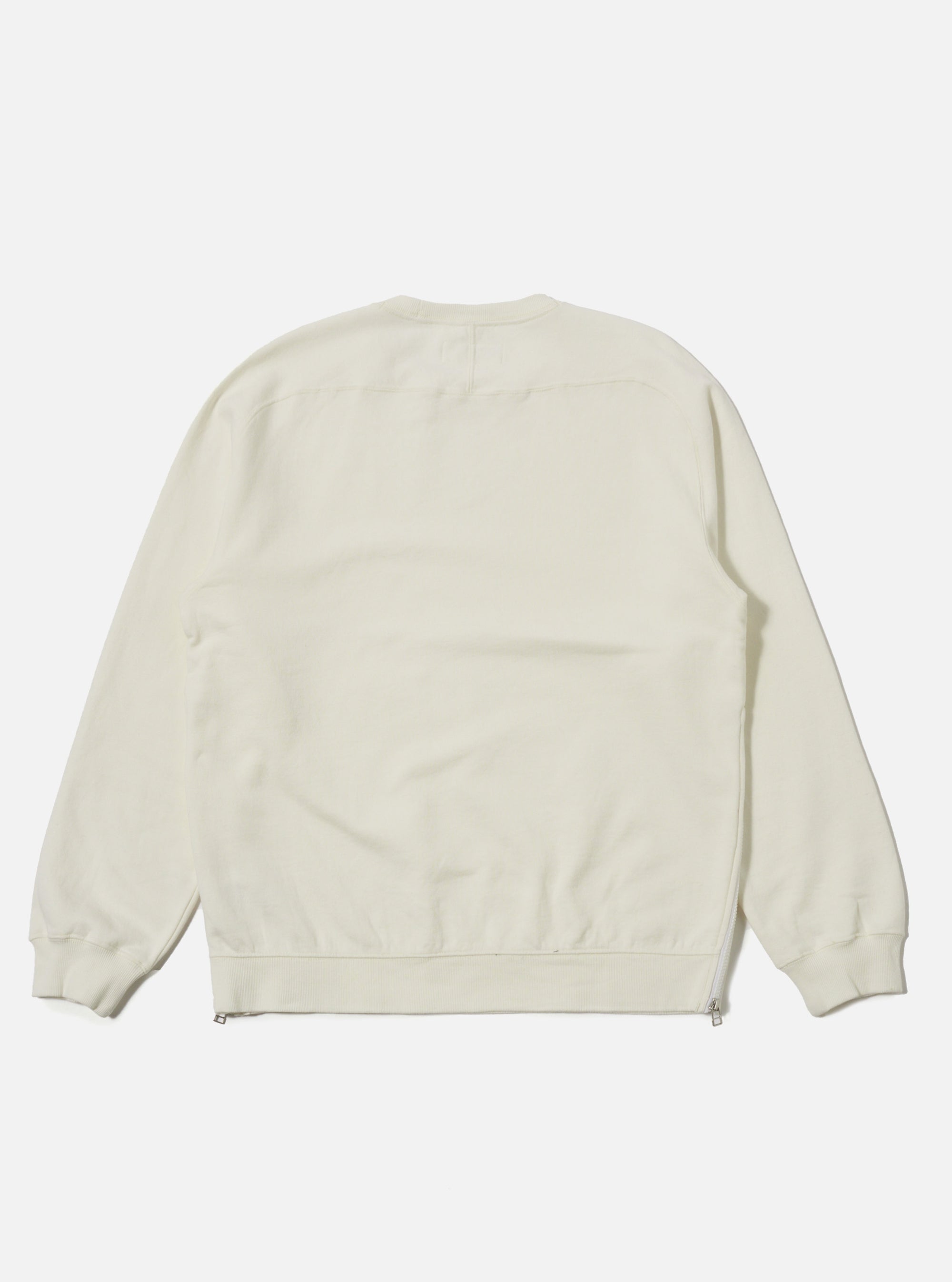 The Ecru Brush Back Sweat Billy Sweat is shown from the back as a flat lay against a plain white background. The sweatshirt features a crew neckline, long sleeves with ribbed cuffs, and a ribbed hem. The fabric is a solid ecru color with a soft, textured appearance.
