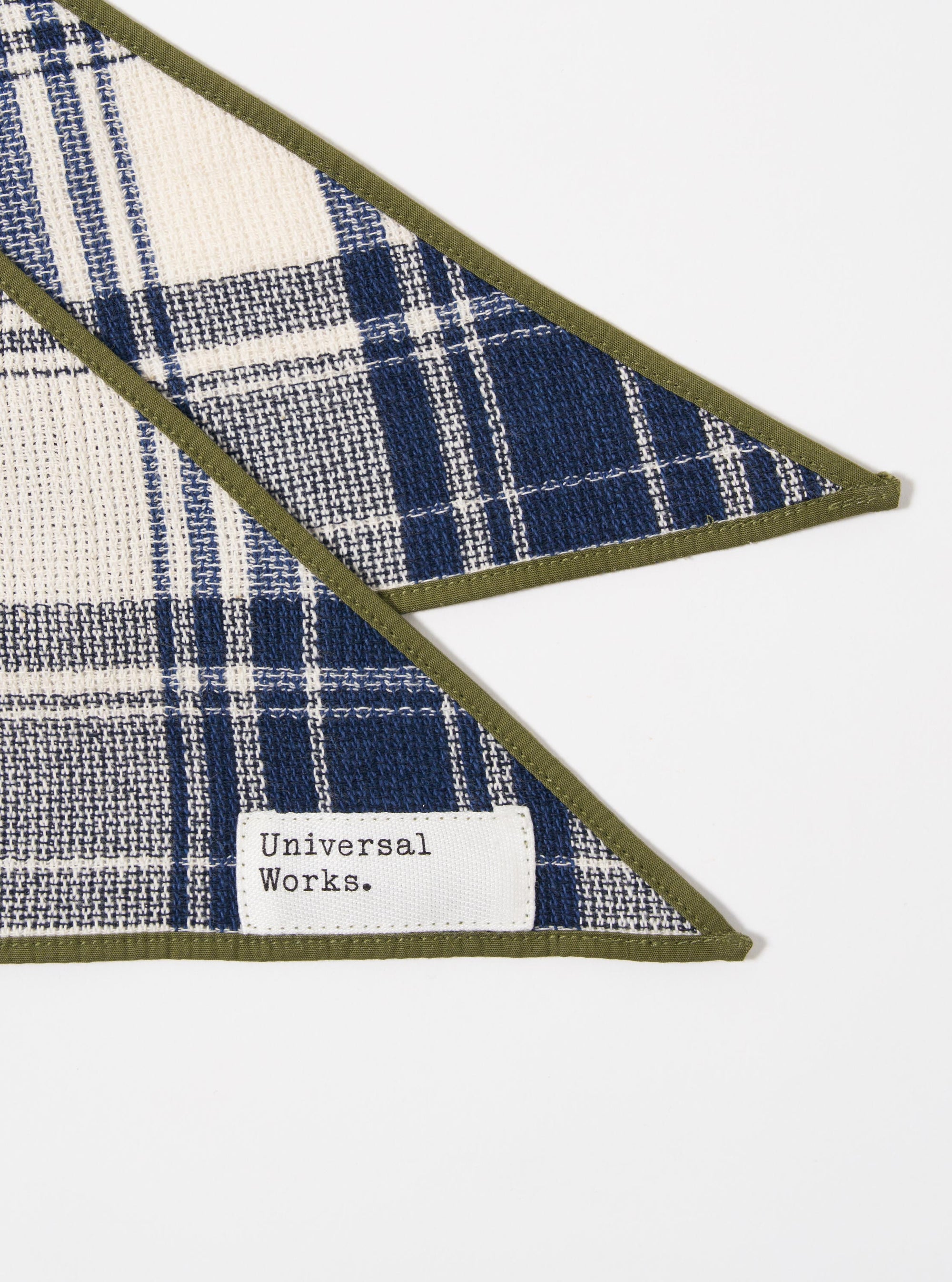The Navy Texture Plaid Scout Scarf is displayed as a flat lay against a plain white background. The scarf features a tonal navy blue plaid pattern with a distinct textured weave. It is folded to highlight the fabric's weight and the clean finish of the edges.