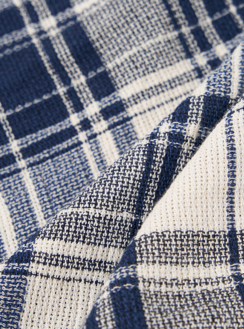 A close-up swatch image of the Navy Texture Plaid Scout Scarf fabric displays a detailed view of the textile. The image features a textured plaid pattern with a navy blue base and intersecting lines. The fabric has a visible weave and a soft, matte finish.