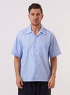 A model wears the Sky Fil A Fil Camp Shirt against a plain, neutral background. The shirt features a relaxed camp collar, a central button-down front, and a single patch pocket on the left chest. The garment is made from a light sky blue cotton fil-a-fil fabric. The model is shown in a front-facing view, wearing the shirt as a top layer.