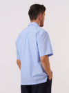 A model wears the Sky Fil A Fil Camp Shirt against a plain white background. The shirt is shown from the back, highlighting the straight yoke, short sleeves, and a straight hem. The light blue cotton fabric has a fine end-on-end texture. No mannequin is present in the image.