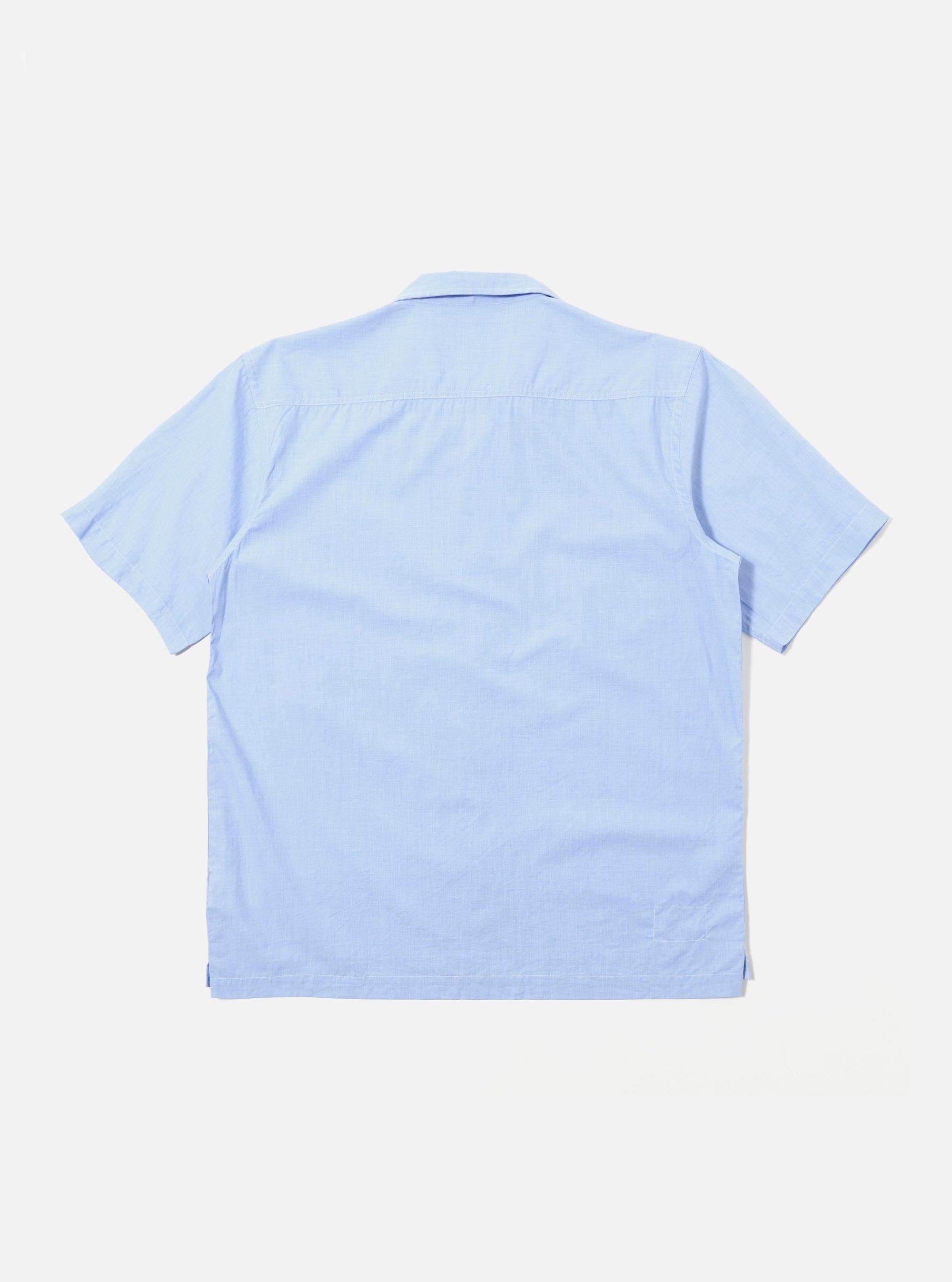 The Sky Fil A Fil Camp Shirt is shown from the back as a flat lay against a plain white background. The image highlights the shirt's short sleeves, straight hem, and the clean construction of the rear panel. The light sky blue Fil A Fil cotton fabric has a fine, textured appearance.