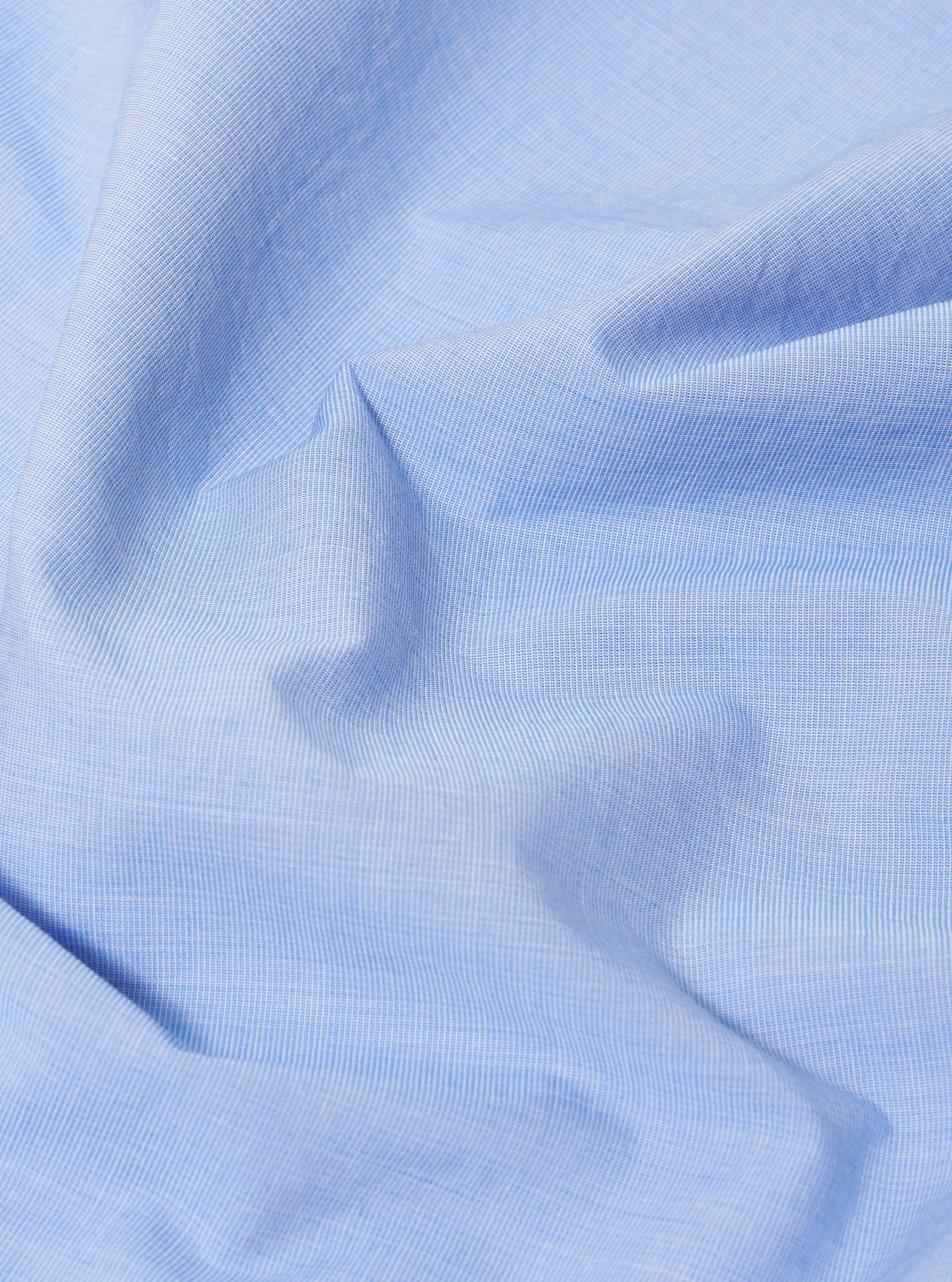 A close-up swatch image of the Sky Fil A Fil Camp Shirt fabric displays a light sky blue color with a fine, two-tone end-on-end weave. The texture of the cotton material is clearly visible, filling the frame against a neutral background.